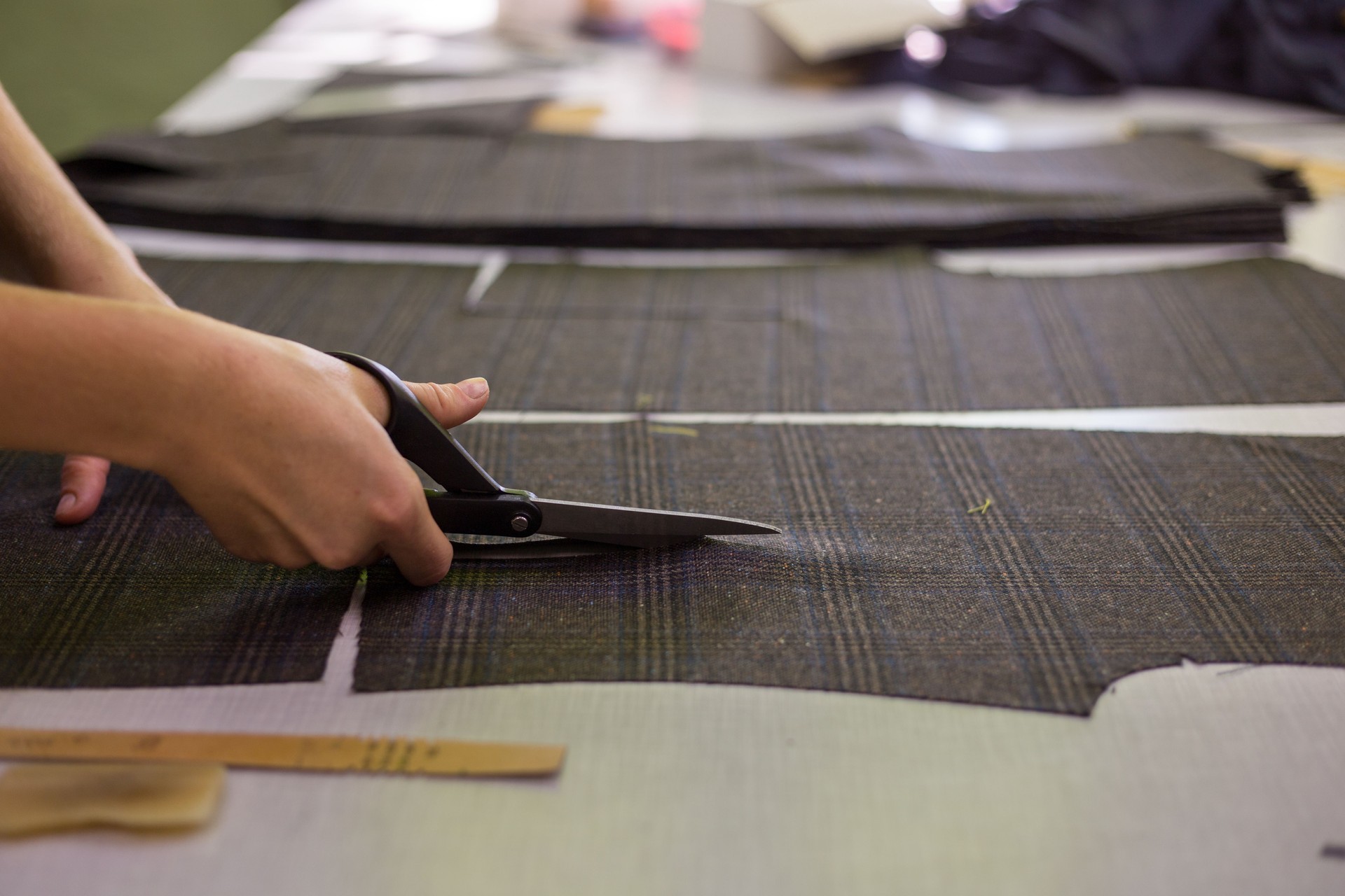 Hand cutting suit jacket pattern pieces in bespoke tailor atelier